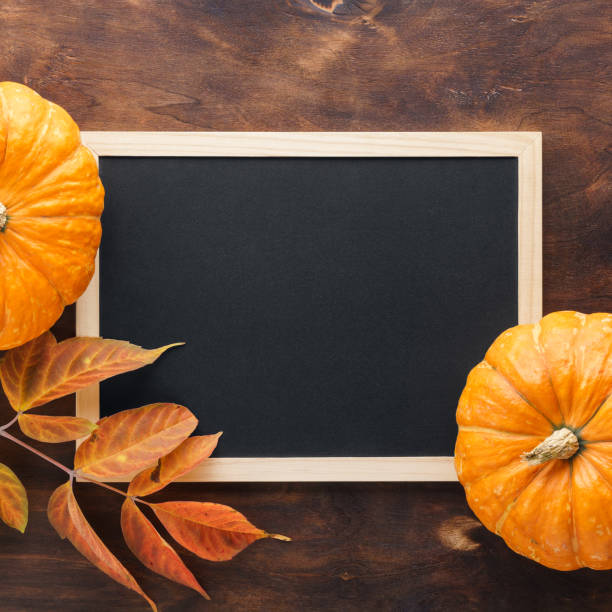 istock Fall chalkboard background with pumpkins, red and yellow leaves. 1160143573