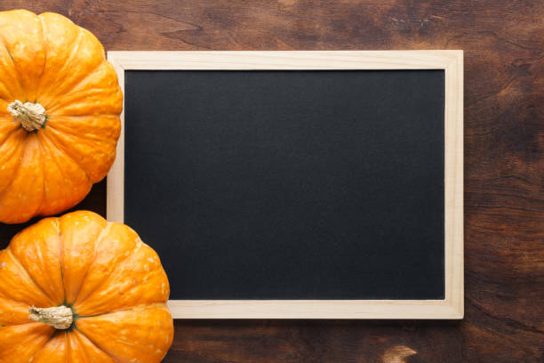 istock Chalkboard with wooden frame and pumpkins. Flat lay. 1160143621