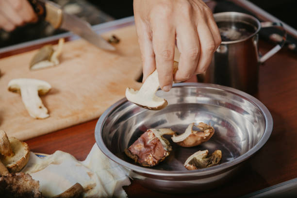 istock Hand pouring sliced mushrooms in bowl 1160143671