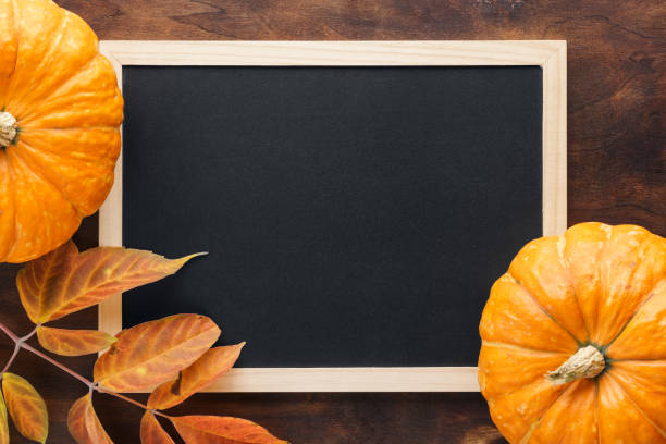 istock Fall chalkboard background with pumpkins, red and yellow leaves. 1160143686