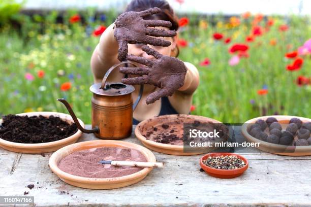 Woman Is Manufacturing Seed Balls Or Seed Bombs On A Wooden Table Flower Field In The Background Stock Photo - Download Image Now