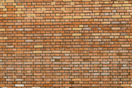 The texture of the brick wall of yellow-orange bricks