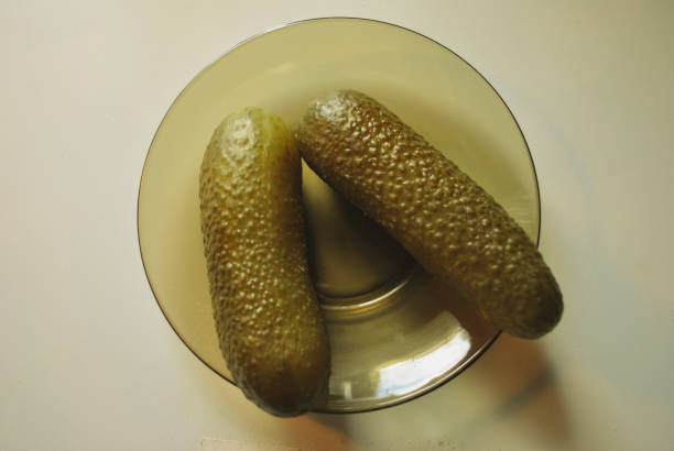 Marinated pickled cucumber on a saucer of dark glass