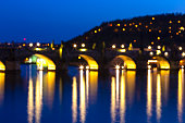 Blurred in the night with bokeh of Charles bridge water reflection, Prague, Czech republic