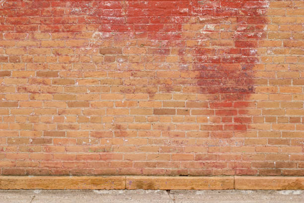 istock Old red blotchy clay brick wall texture with peeling and worn red paint 1160150444