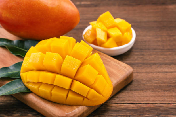 istock Fresh chopped mango cubes on wooden cutting board and rustic timber background. Tropical summer fruit concept, close up, macro, copy space. 1160152487