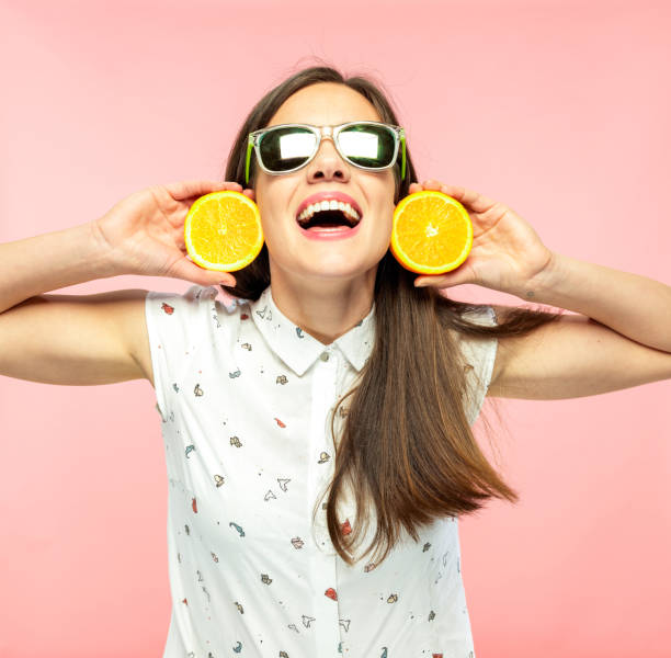 istock Cheerful Young Woman Smiling and Holding Halfed Orange 1160154637