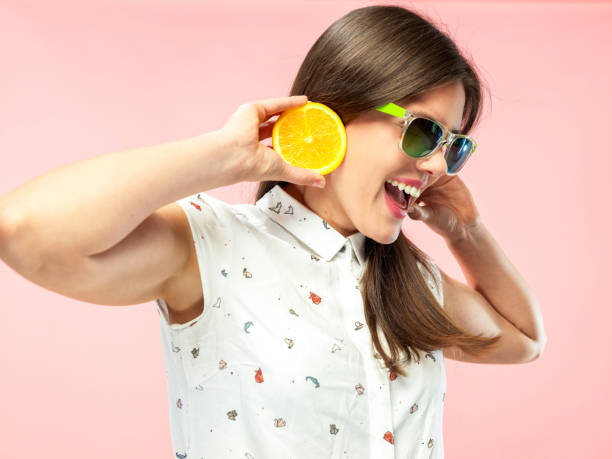 istock Cheerful Young Woman Smiling and Holding Halfed Orange 1160154647