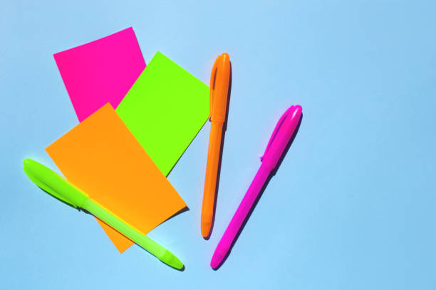 istock Neon colorful sticky note paper and pen on blue background. 1160158985