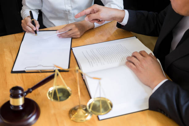 midsection of lawyer pointing at document while sitting with customer on table - human hand hand sign measuring scale imagens e fotografias de stock