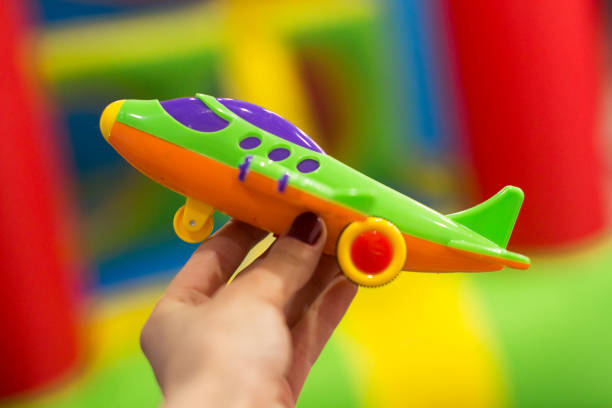 young woman plaaying with a toy green airplane