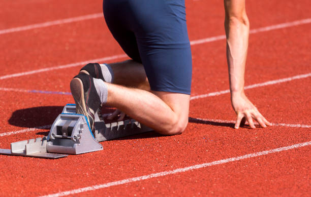 istock Low Section Of Sprinter Kneeling At Starting Line 1160174244