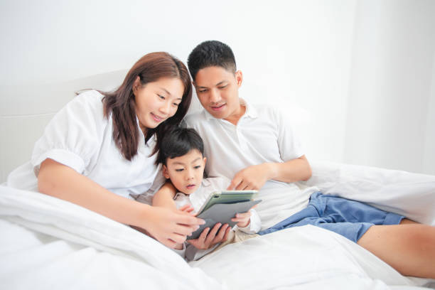 istock family and son watching and  play tablet on bed 1160174889