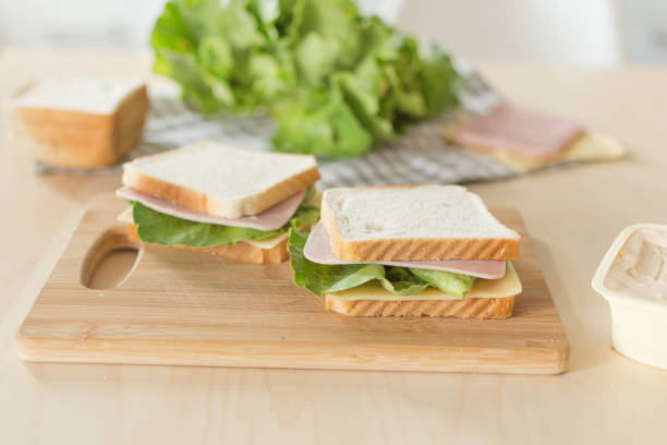 istock Sandwich with cheese and ham on cutting board on the table in the bright kitchen. 1160178039