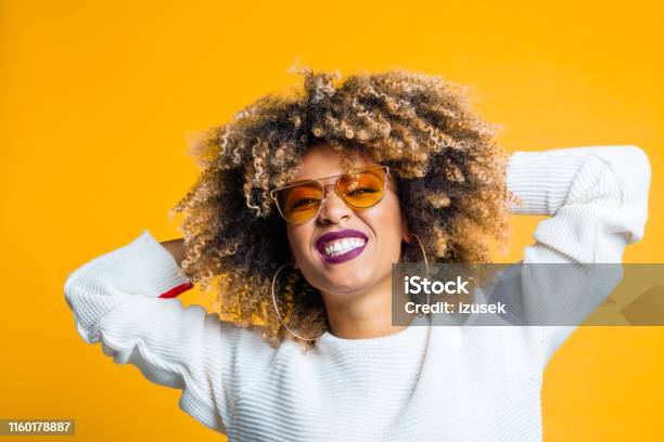Pretty Young Woman Enjoying On Yellow Background Stock Photo - Download Image Now - Women, Sunglasses, Yellow Background