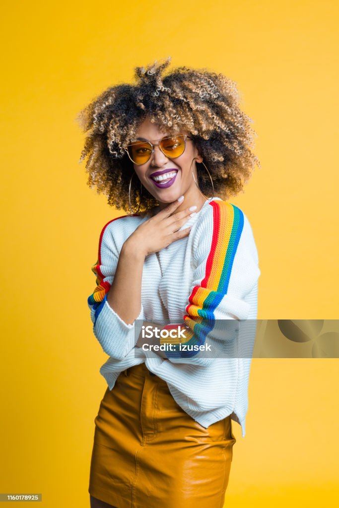 Portrait of pretty afro young woman Portrait of pretty afro young woman smiling against yellow background Women Stock Photo