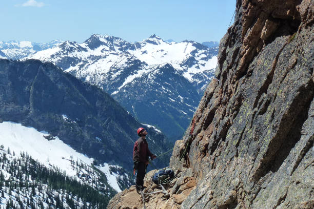 Liberty Bell, Washington - July 6th, 2012: A climber belaying at the first pitch of Beckey Route on Liberty Bell in Washington USA.