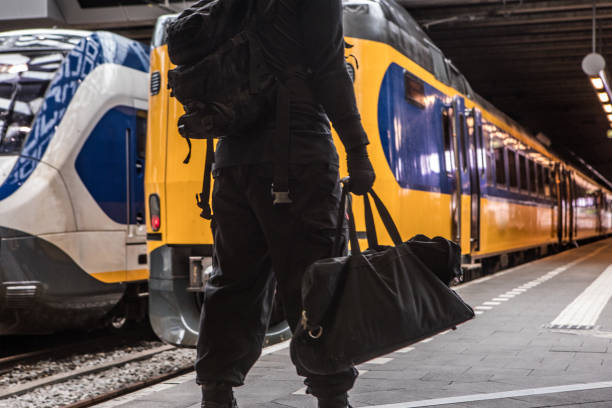 istock Dark hooded terrorist figure at public transport hub 1160179487