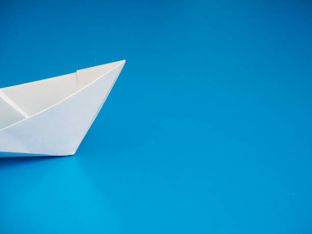 istock Single light white origami boat on blue background, Leadership concept 1160180063