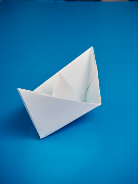istock Single light white origami boat on blue background, Leadership concept 1160180067