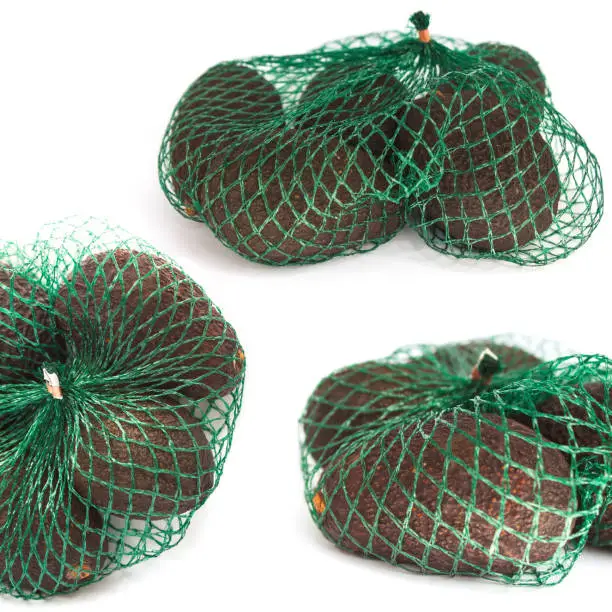 Fresh organic hass avocados in a green string bag on a white background isolated, food collage, photo set, healthy eating concept, copy space.