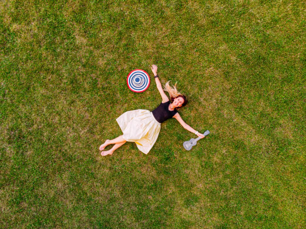 istock Happy Young Woman Lying on the Grass 1160182570