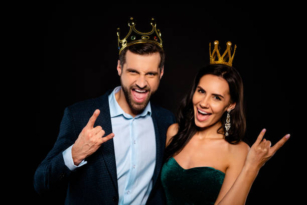 Close-up portrait of his he her she nice-looking gorgeous fascinating attractive luxury confident cheerful cheery two person life lifestyle showing rock roll sign isolated over black background Close-up portrait of his he her she nice-looking gorgeous fascinating, attractive luxury confident cheerful cheery two person life lifestyle showing rock roll sign isolated over black background princess crown tiara prom stock pictures, royalty-free photos & images