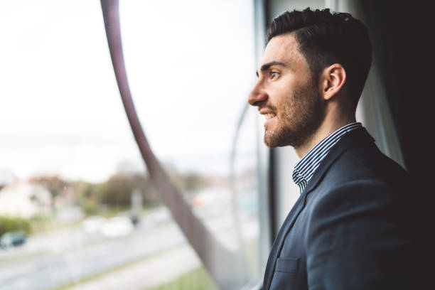 istock A young businessman in a suit looking through the window 1160183244