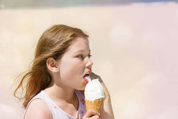 istock BEAUTIFUL YOUNG GIRL EATING AN ICE CREAM 1160184320