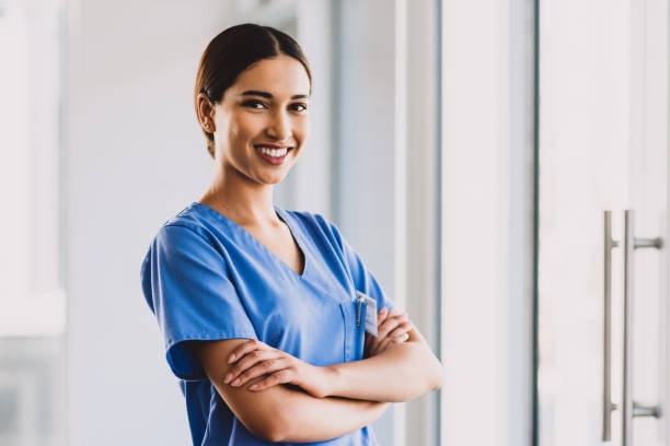 I am proud of my career choice Cropped portrait of an attractive young nurse standing with her arms folded and smiling while in her office female nurse photos stock pictures, royalty-free photos & images