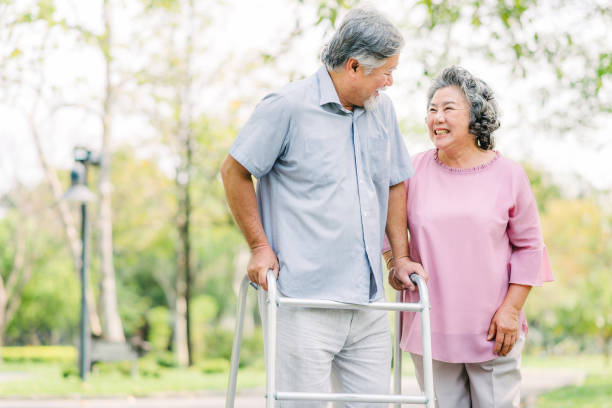 istock senior Asian couple laughing while walking with walker 1160188576