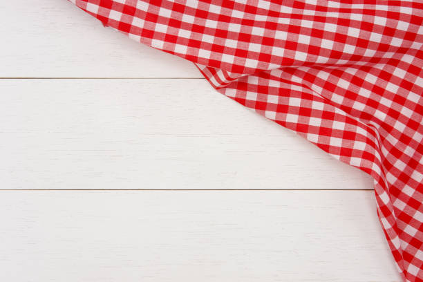 istock Wrinkled red gingham fabric on rustic white wood plank background. 1160188714