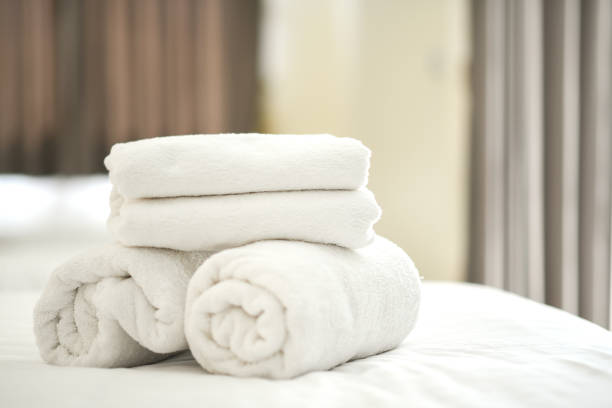 istock Folded white towels placed on the bed in the room. 1160189751