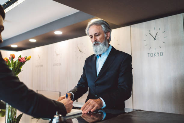 istock Businessman checking in a hotel with an older receptionist 1160189848
