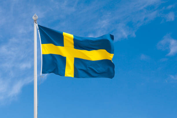 Swedish flag Close-up on a Swedish flag waving atop of its flagpole. sweden flag stock pictures, royalty-free photos & images