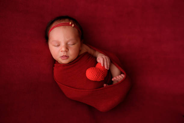 istock Newborn girl sleeping on a red cloth in a red wrapper 1160191584