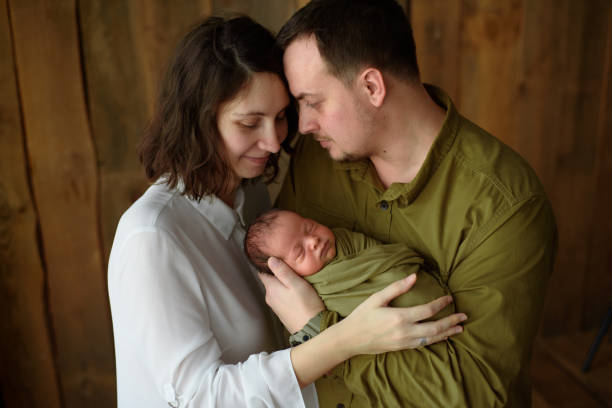 Parents hold their newborn son in their arms stock photo