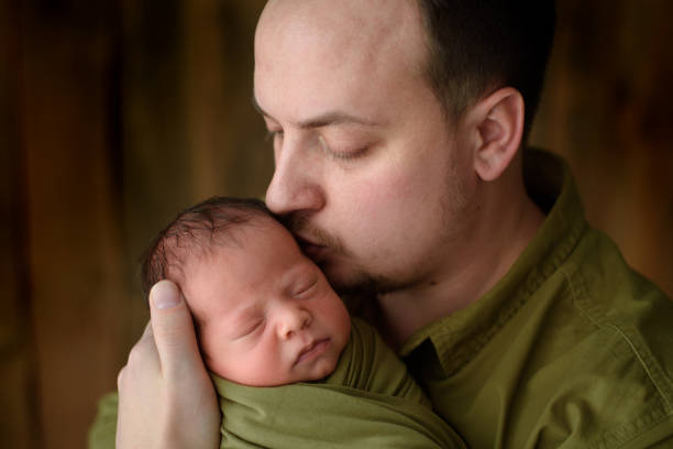 istock Father holds with love his newborn son. 1160191723