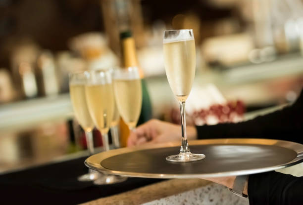 istock Waitress holding a tray with a champagne at the bar 1160192106