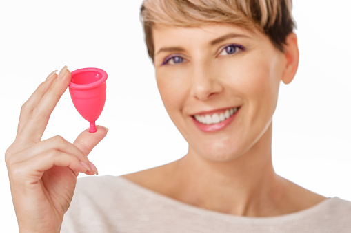 Feliz joven sosteniendo una copa menstrual de silicona photo
