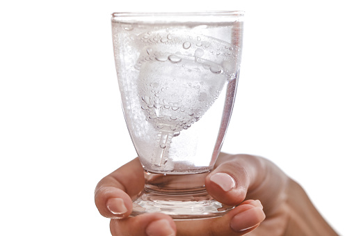 Copa menstrual y comprimido esterilizante en un vaso photo