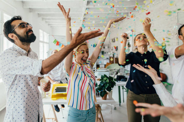 Celebration in the office Photo of a group of coworkers having a happy occasion and celebrating together in their office celebratory event stock pictures, royalty-free photos & images