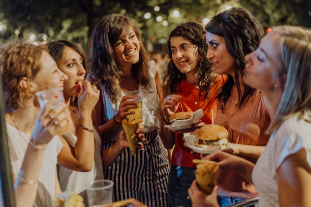 istock Happy friends having fun together, eating hamburger and drinking beer 1160197481