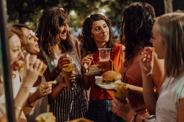 istock Happy friends having fun together, eating hamburger and drinking beer 1160197486