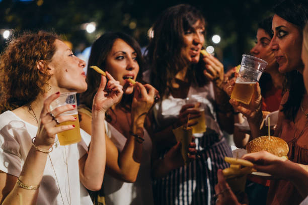 istock Happy friends having fun together, eating hamburger and drinking beer 1160197488