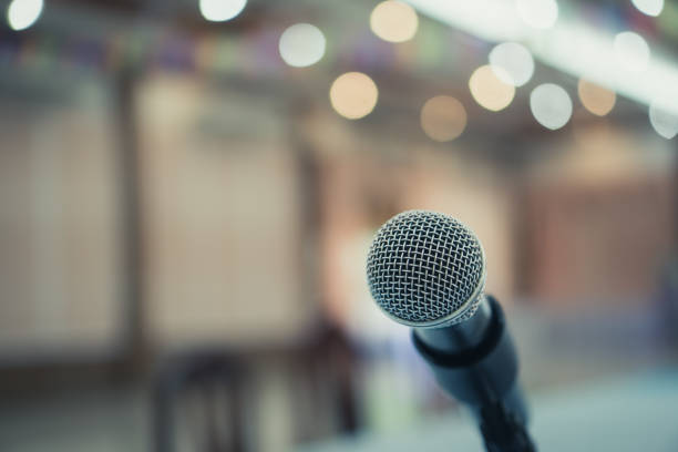 istock Microphone on abstract blurred conference hall prepare for speaker on stage in seminar room. lecture to audience university with bokeh background. Business meeting or education teaching image 1160202478