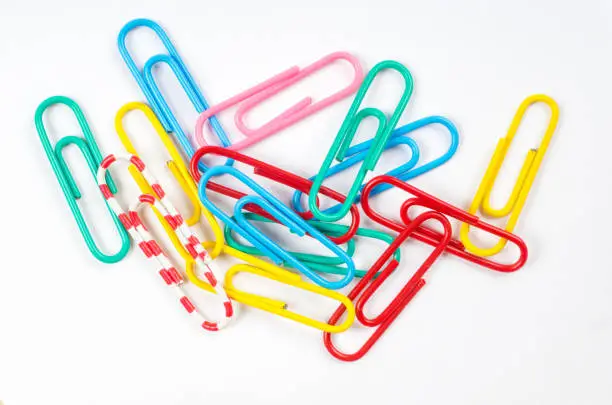 colored paper clips on white background