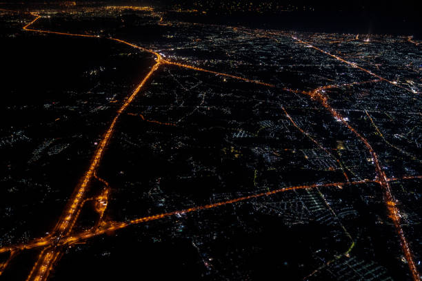赤い空と街の光と夕暮れ時のジェット機からの夜景。 - airport airplane landing red ストックフォトと画像