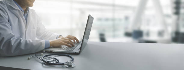 istock doctor working on laptop computer in modern clinics office. copy space 1160214525
