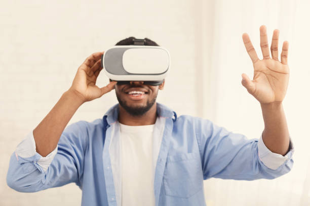 istock Cheerful man trying vr glasses at home 1160220775